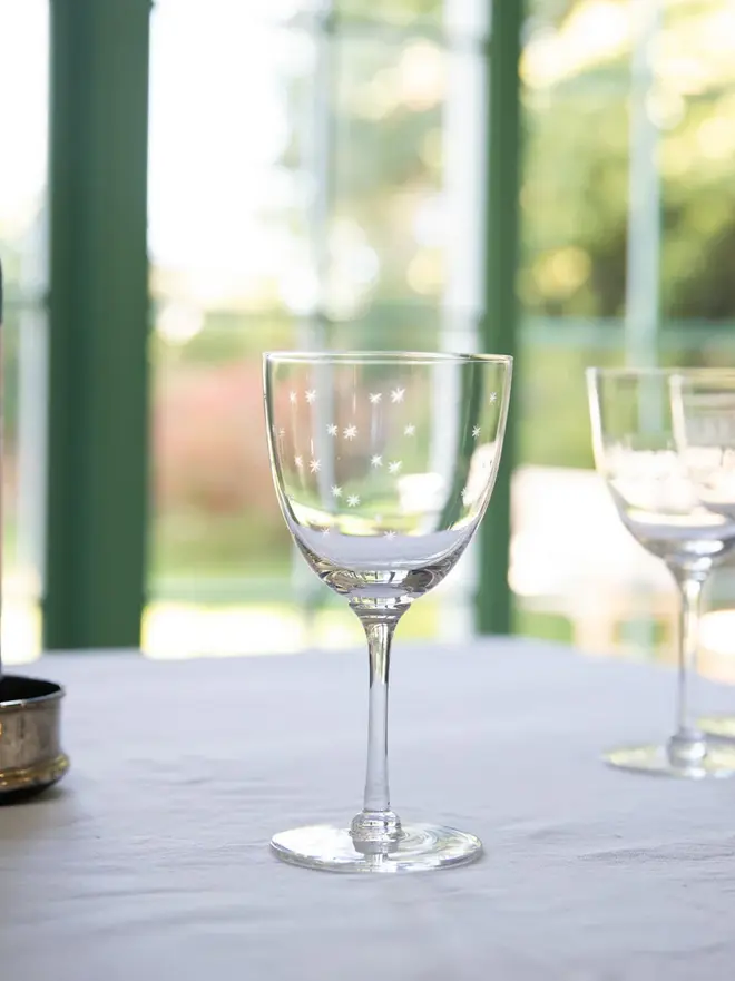 engraved stars large crystal wine glasses. a large wine glass patterned with small stars.