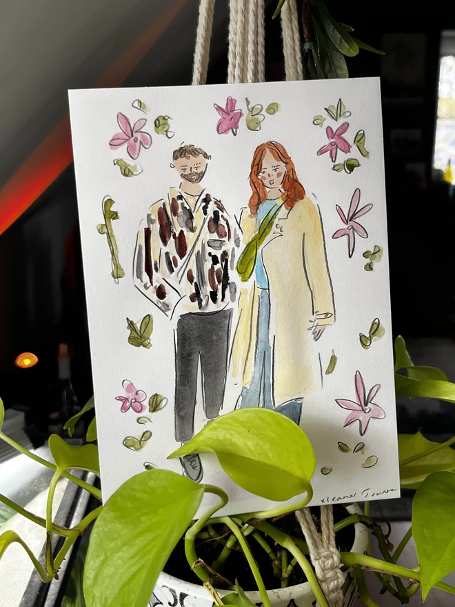 A hand-painted A5-sized personalised portrait of two people by Eleanor Joanna, illustrated in a whimsical style. The background is fully customisable to reflect the buyer's preferences, making it a unique and tailored piece of art.