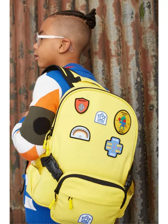 Kid wearing the Beltbackpack in yellow decorated with colourful Pachee patches.