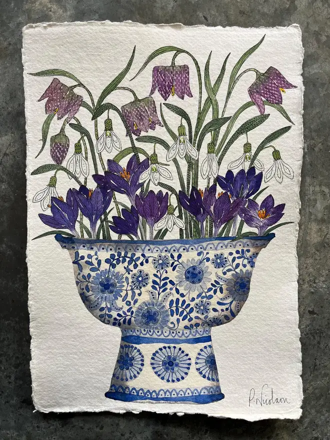 crocus, snowdrops and fritillary flowers in a blue and white, patterned ceramic vessel