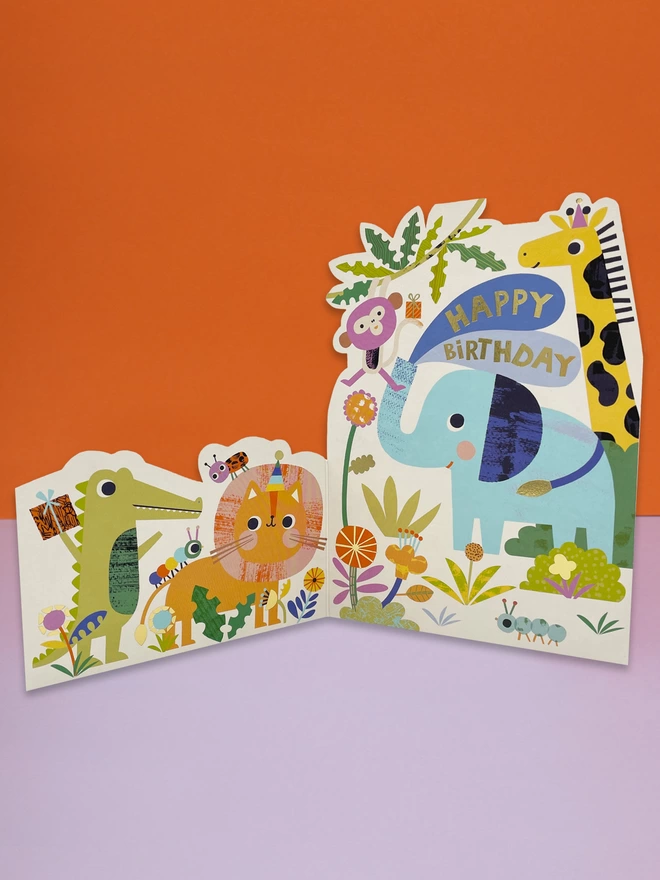 A vibrant safari themed die cut children’s birthday card, with colourful safari animals of all shapes and sizes. The card is complete with gold foil details and a gold foil ‘Happy Birthday’ message
