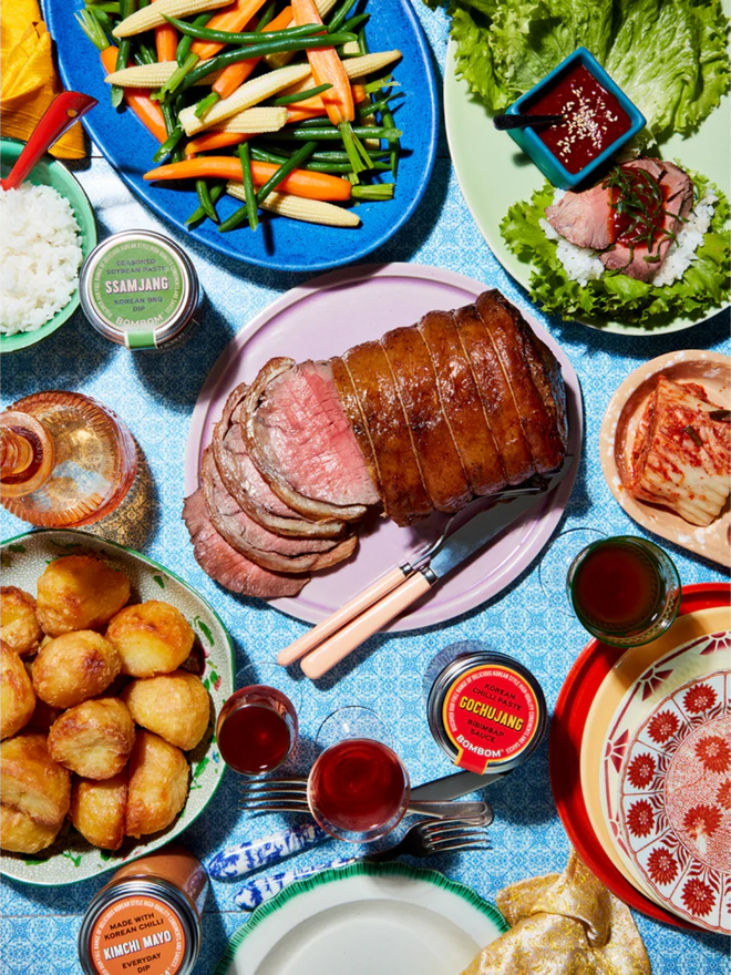 korean ssamjang sauce. a table full of different food dishes (including meat, salad and potatoes) alongside a jar of korean ssamjang sauce.