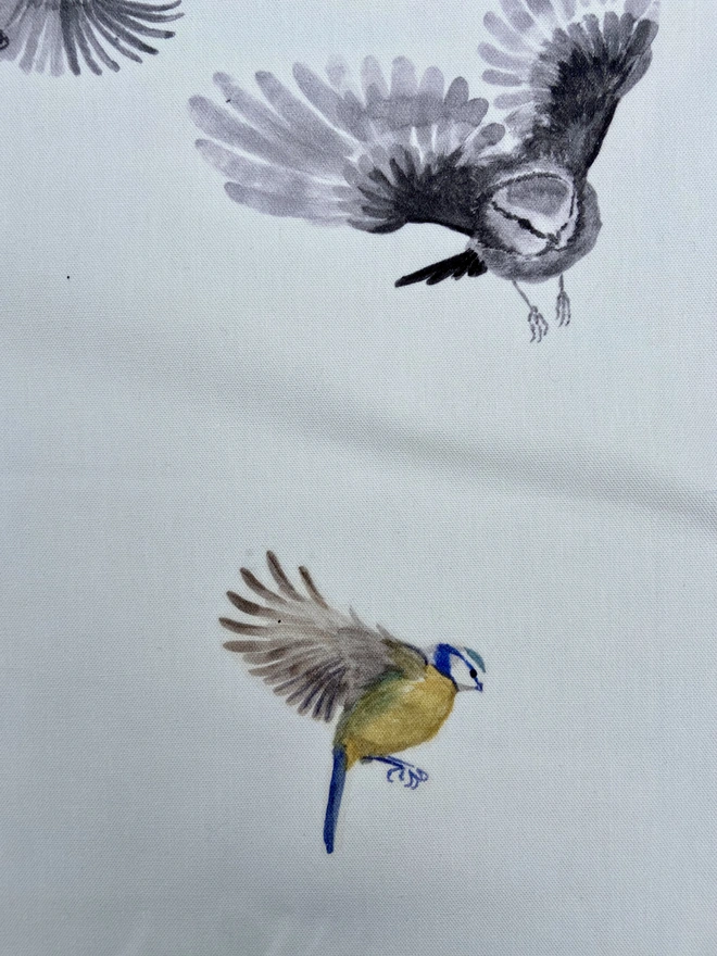 Hand painted birds on white linen tablecloth, perfect for a summer garden table or a wedding breakfast