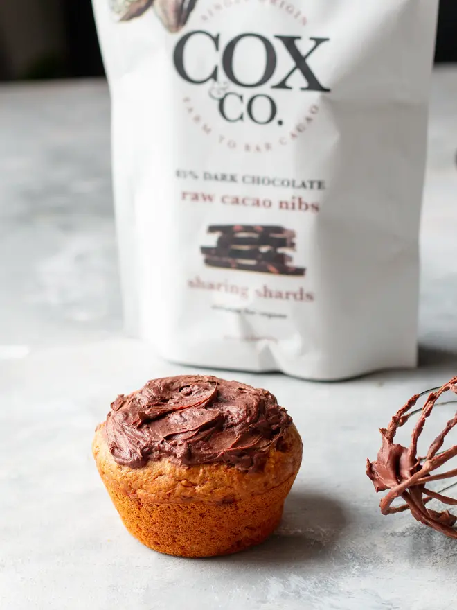Cox&Co Sharing Shards Pouch - Raw Cacao Nibs, a chocolate treat sat next to a chocolate pouch. 