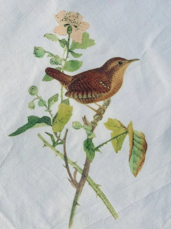 A white cotton napkin printed with a vintage illustration of a wren