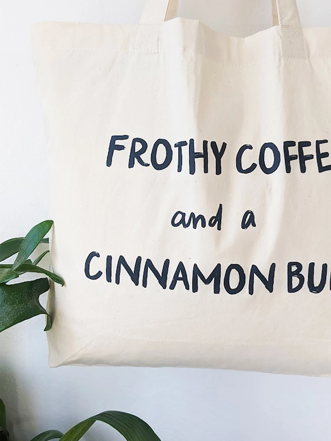 A natural coloured canvas tote bag with black Frothy Coffee slogan.