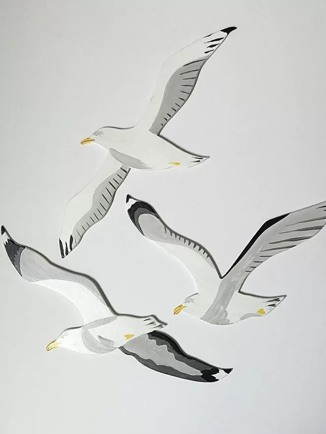 Wooden set of 3 seagulls on a white wall
