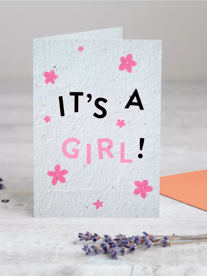 'It's A Girl’ New Baby Plantable Card with Pink Flower Illustrations standing up with Lavender in front