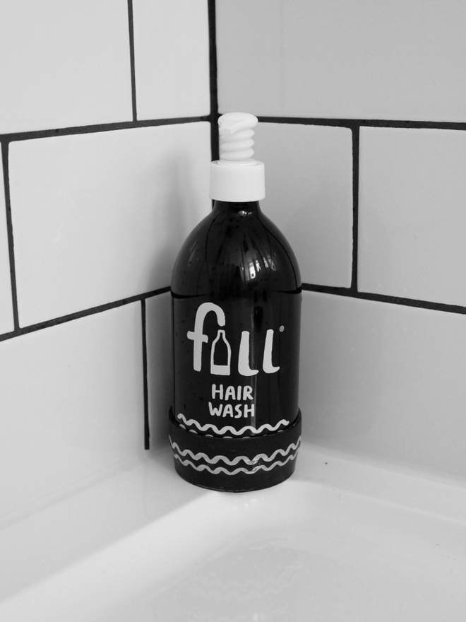 Hair Wash. A bottle on the side of a bath.