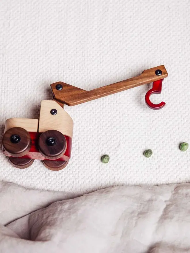 Walnut & Padauk Crane Wood Heirloom Toy, on a white table. 