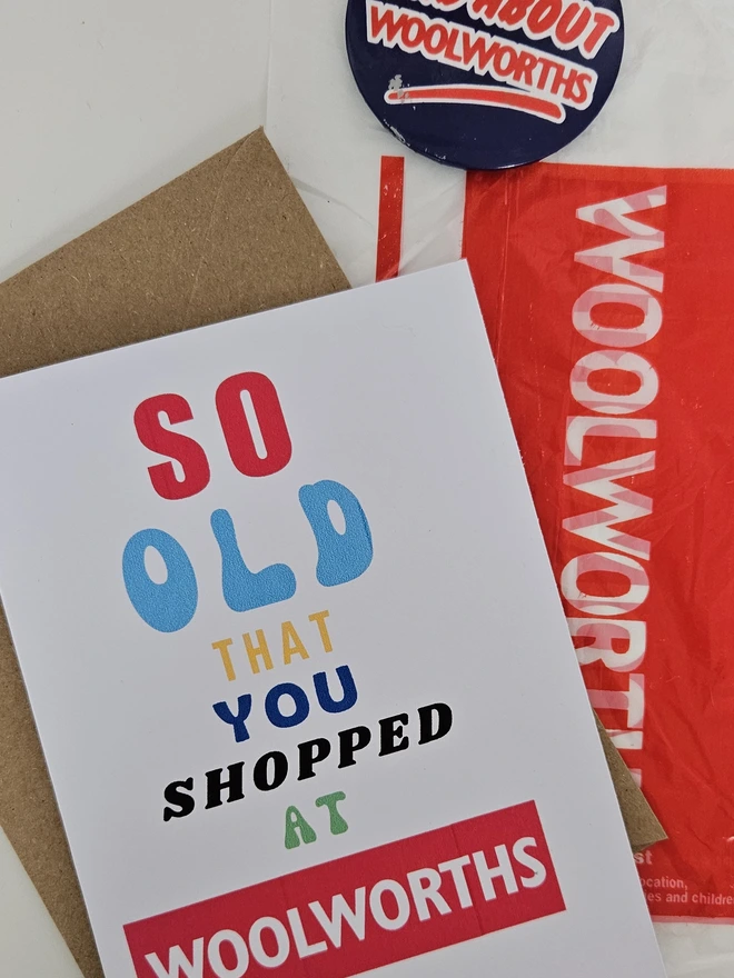 A photograph of the front of a humorous A6 greeting card illustrated using brightly coloured text and the retro shop logo. The text says so old you shopped at Woolworths with a vintage badge that says I'm mad about Woolworths and a vintage Woolworths plastic bag.