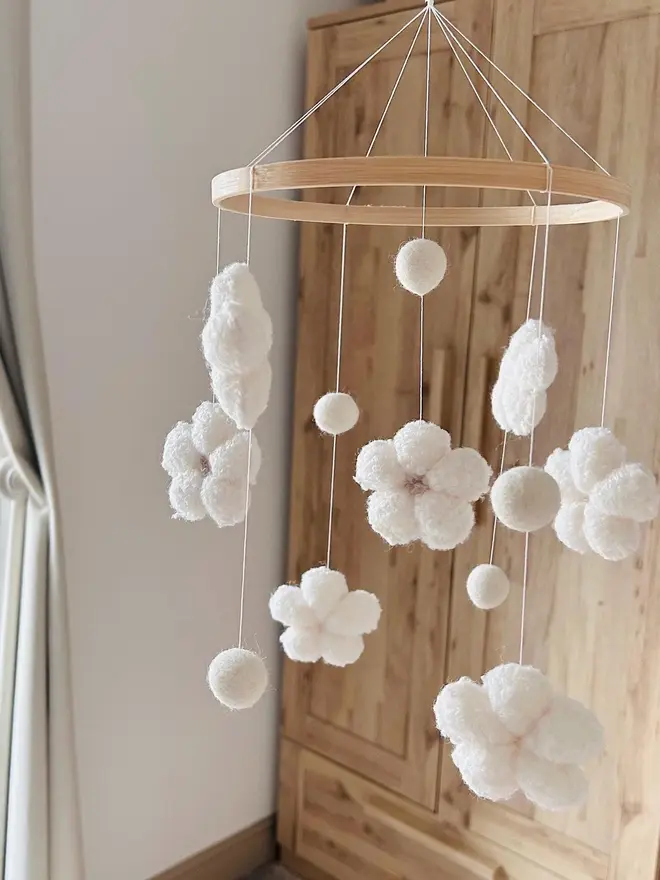 boucle flower baby mobile. a white cloth baby mobile hanging from the ceiling.