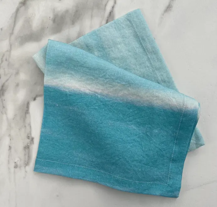 Azzurro Napkins (Set of 4). Light blue cloth napkin tied with natural twine, styled on a marble background.