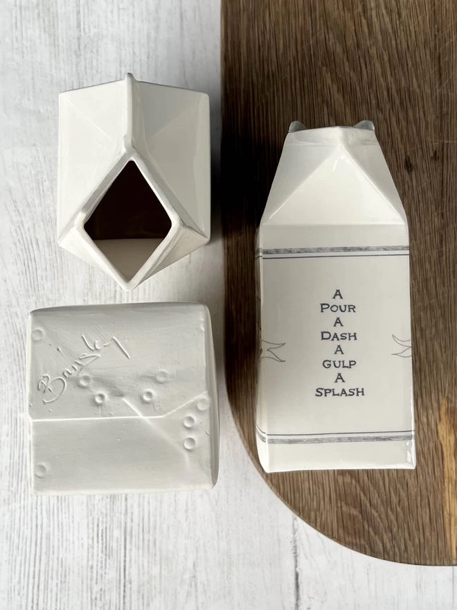 3 handmade milk cartons showing views from above, side and base that has Brinsley signed on it.
