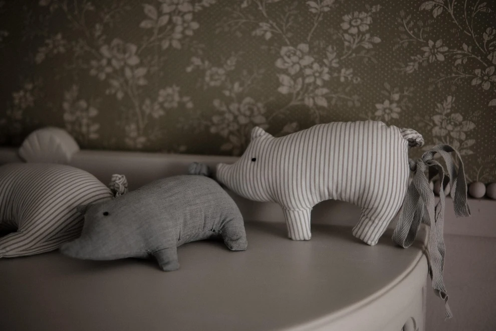Pig Garland Decoration, a grey and white pig garland decoration in a child's bedroom. It is accompanied by other bedroom accessories. 