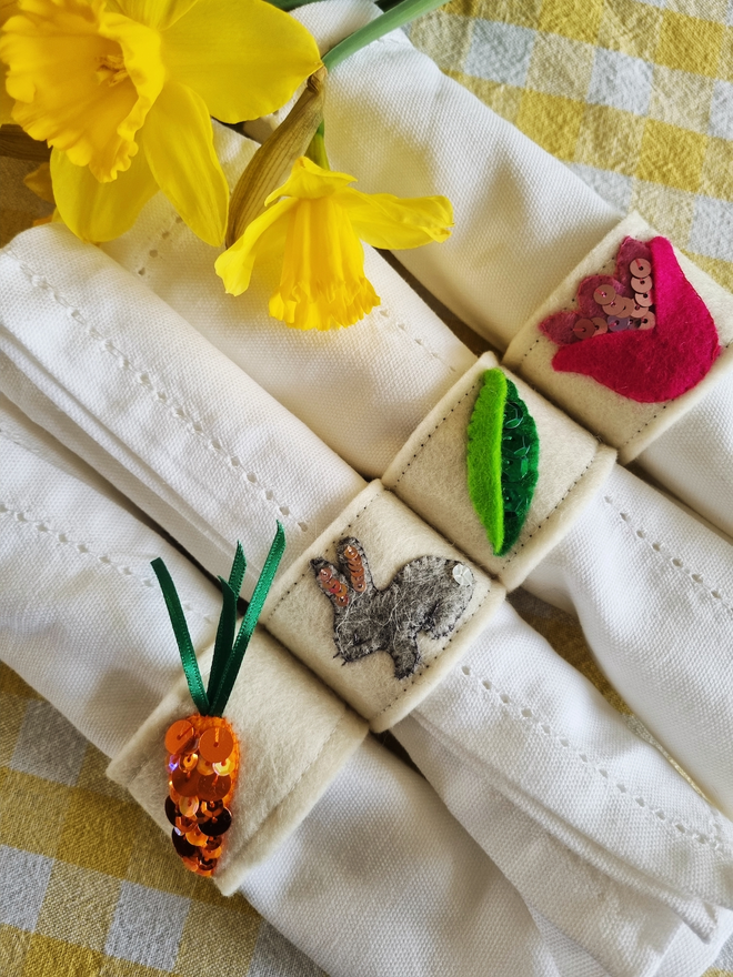A close up of the napkin ring set, showing the carrot, bunny, peapod and tulip