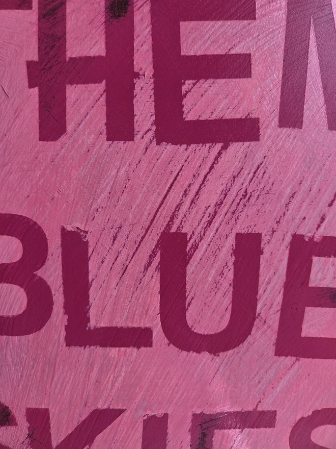 Close up of lettering on painted vintage wooden cabinet with pink, blue and floral decoration
