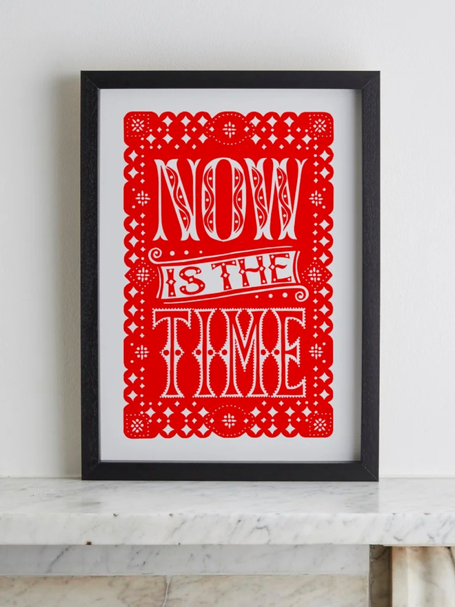 now is the time linocut. a linocut phrase printed on red paint.