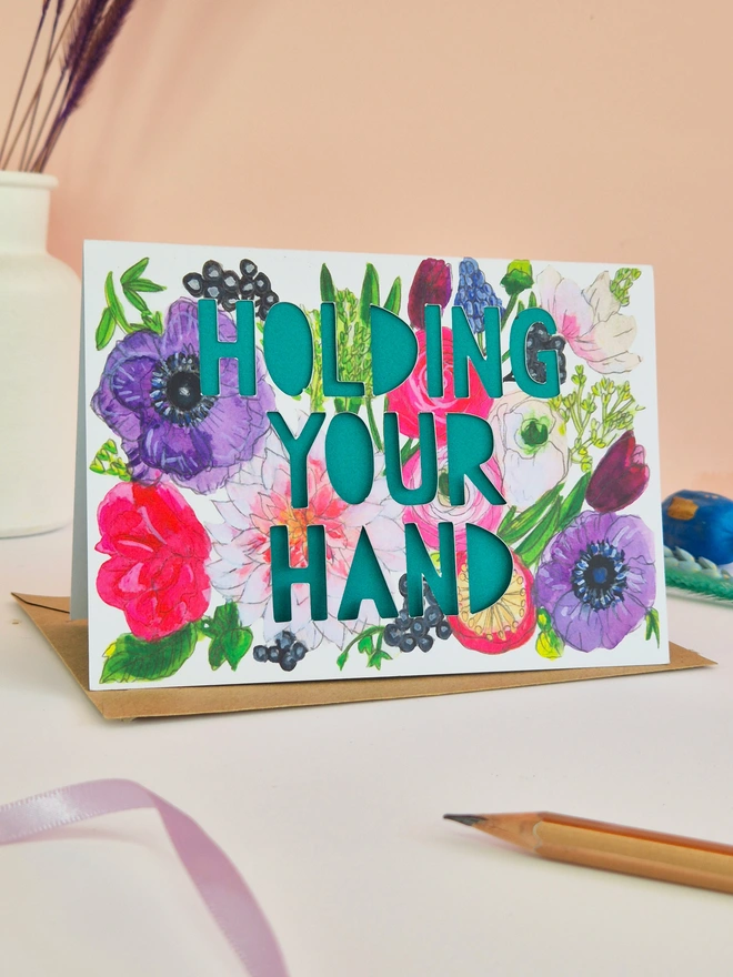 Floral illustration card with Holding your hand paper cut text and green backing paper 