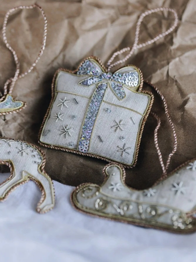 embroidered linen present decoration. christmas present hanging ornament photographed on brown wrapping paper.