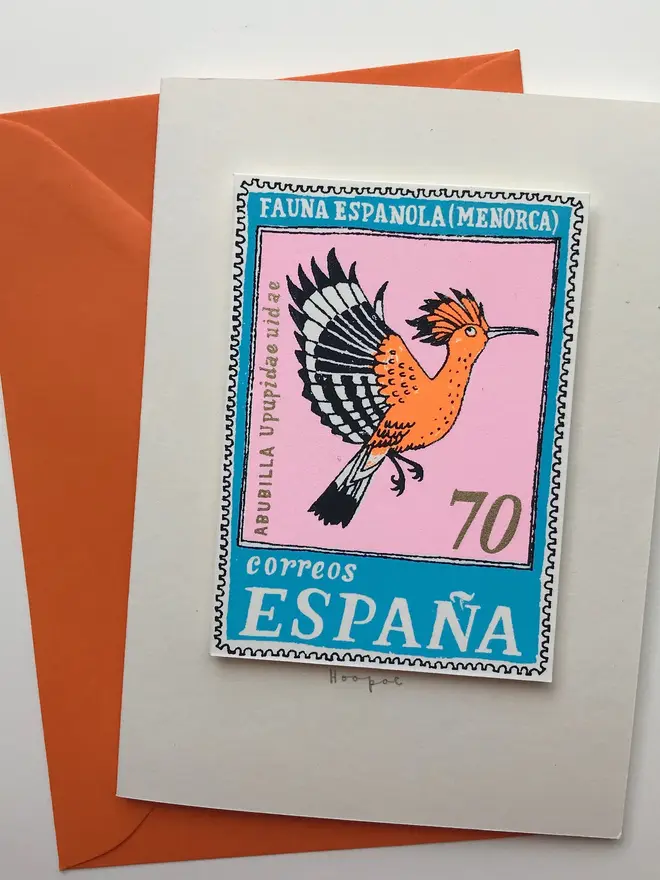 Bird Stamp Card Spain/ Hoopoe Card, a white card with a bird design in the middle against an orange envelope on a white background. 