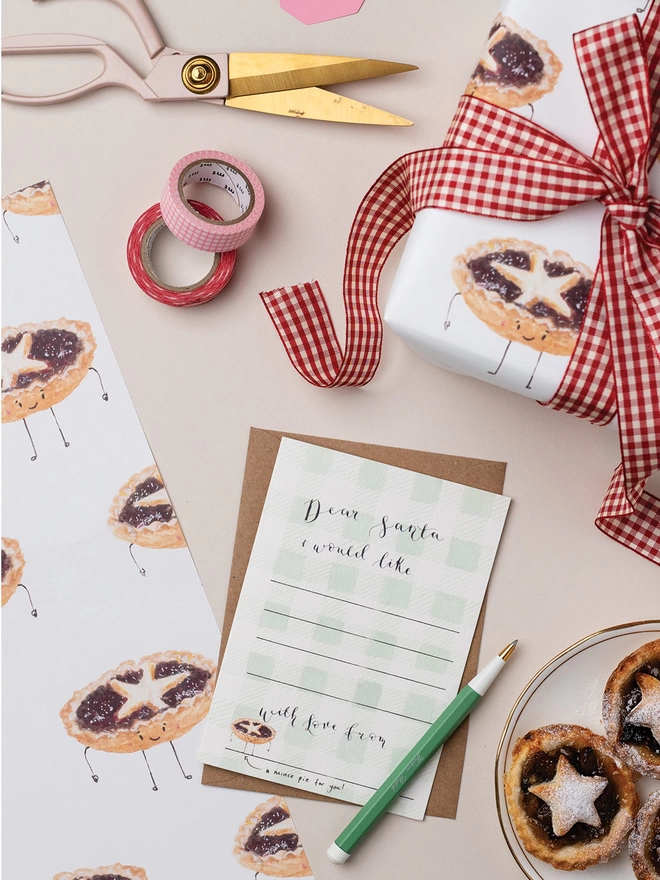 Mince Pie Gift Wrapping Scene with a Plate of Mince Pies, Scissors, Wrapping paper and a Christmas Card