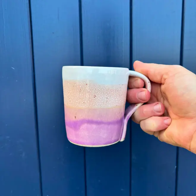 Ice Cream Sundae Standard Mug, a person holding a colourful mug against a navy blue wooden backdrop. 