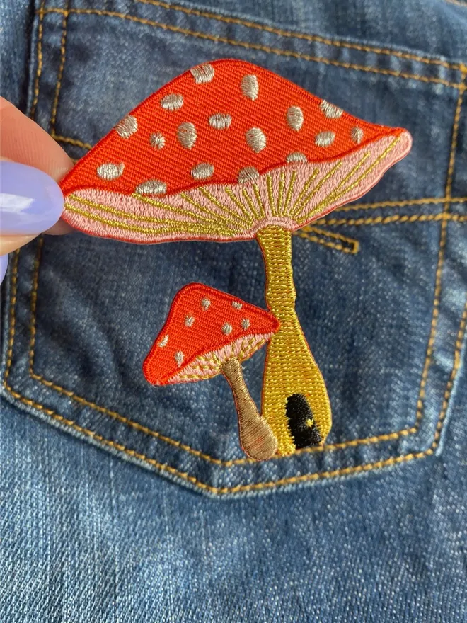 Toadstool embroidered iron on patch on denim.
