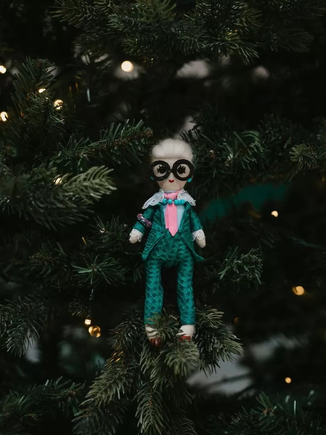 Iris Apfel Jennifer Jackson doll seen standing in a Christmas tree.