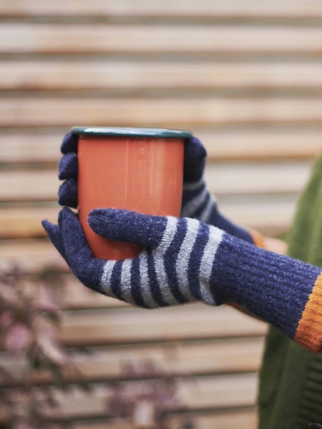Women's Lambswool Gloves, a woman wearing a pair of colourful gloves outdoors. 