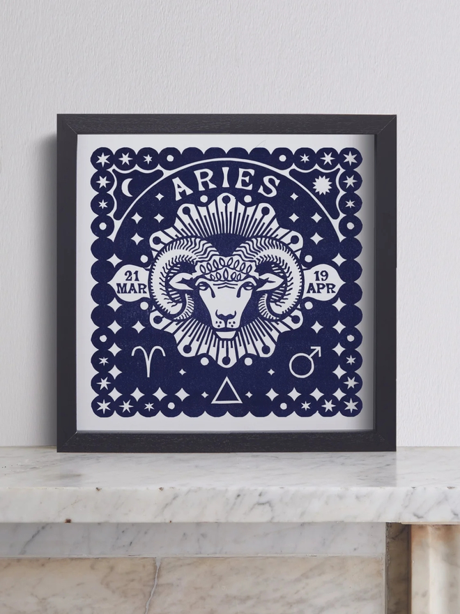 aries zodiac linocut. a ram and zodiac signs linocut and printed on a blue background.