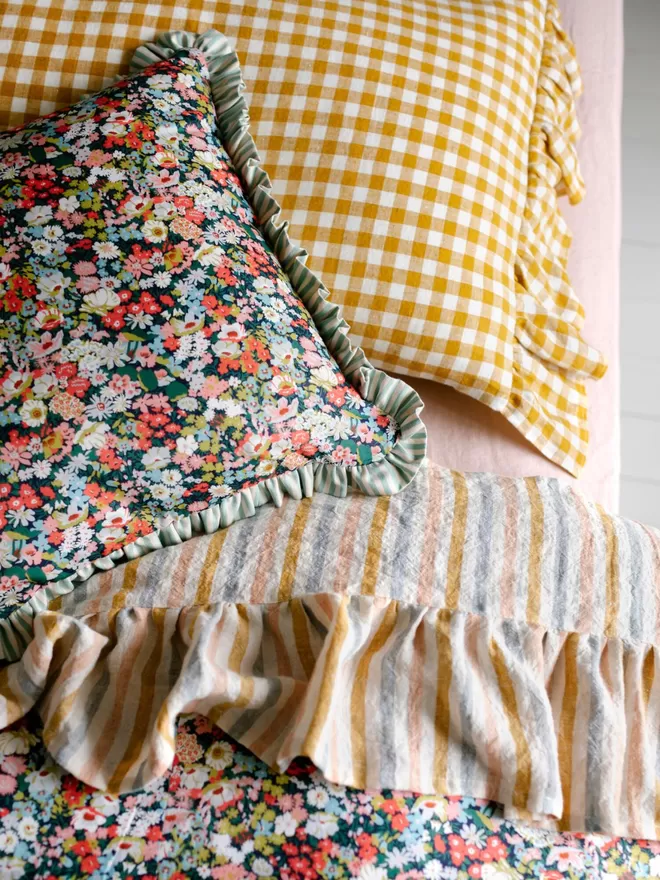 Stripy trim cushion made with Liberty fabric 'Thorpe' close up of the cushion on the bed 