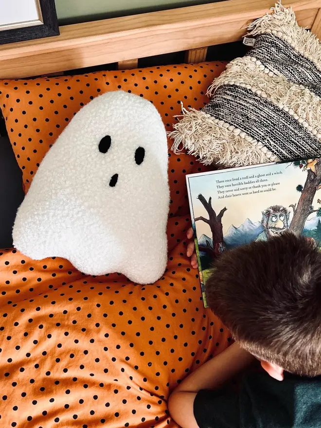 boucle ghost pillow. a white cushion in the shape of a ghost.