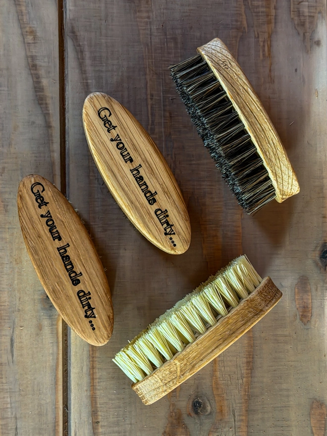 Close-up of the Get your hands dirty engraving on the oak nail brush