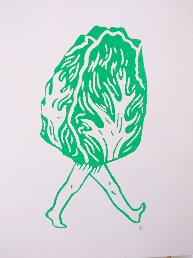 a close up of the print which is a graphic lettuce with legs