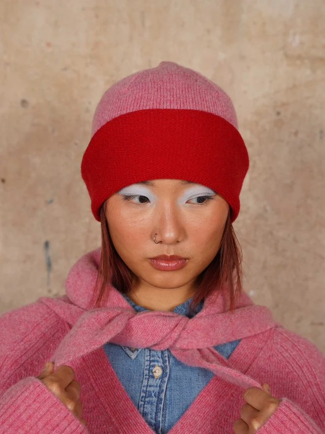 Model wearing the Colour Block Beanie in French Rose & Rouge along with the neck tie and matching jumper
