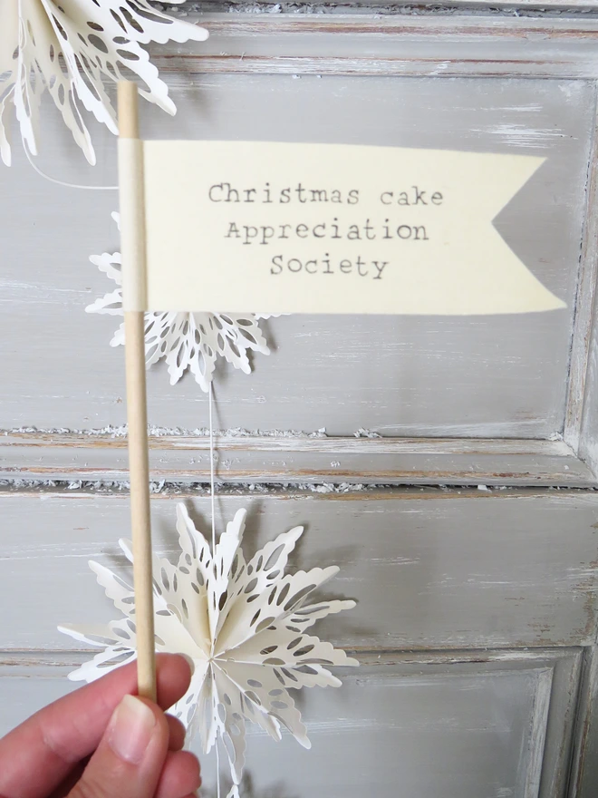 Organic cotton flag hand painted with festive message wrapped around a wooden dowel