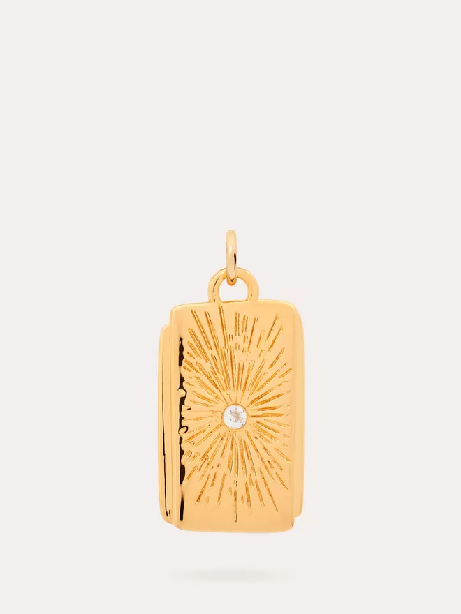 front view of a Starburst gold Pendant finished with an engraved star and a white topaz stone