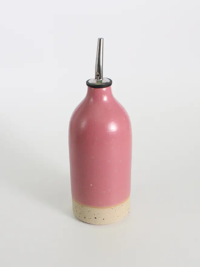 Large ceramic oil pourer in fuchsia against a white background