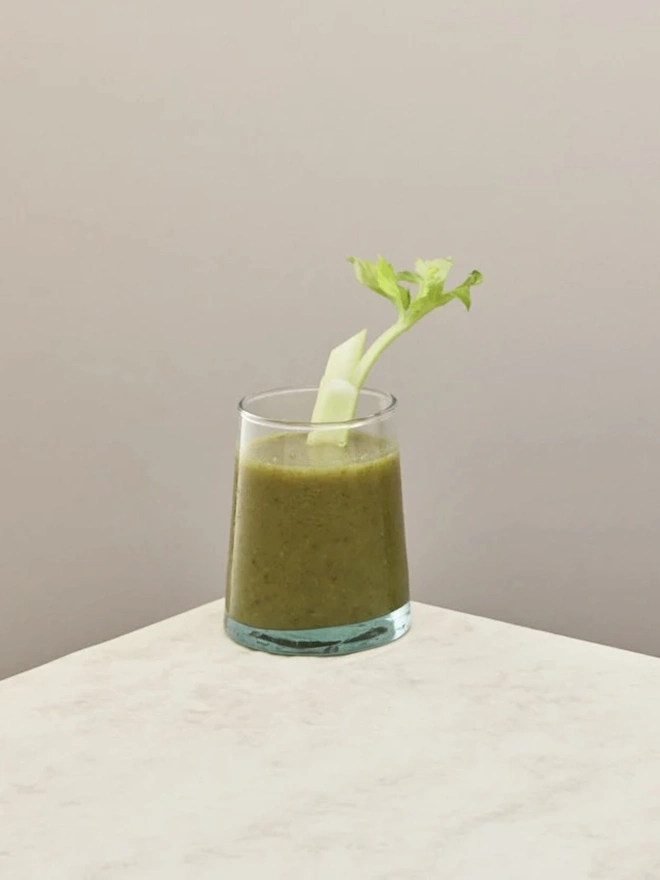 Tumbler Glasses (Set Of 1 Or 4), a tumbler glass sitting on a plain counter top against a plain backdrop. The glass contains a soft drink in it. 