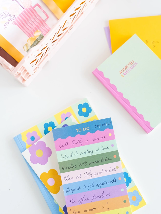 Colourful 'To Do' list pad sits on a pile of notebooks from the Raspberry Blossom Happiness stationery collection