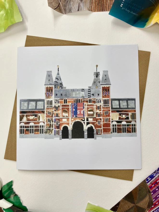 A greetings card showing a paper collage of the Rijksmuseum with a brown envelope on a white background with paper materials