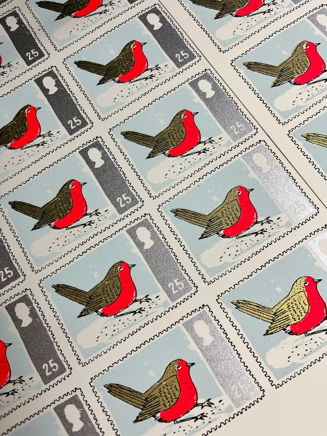 Robin Stamp Christmas Card, a group of white Christmas cards with colourful bird designs in the centre on a large sheet of paper. 