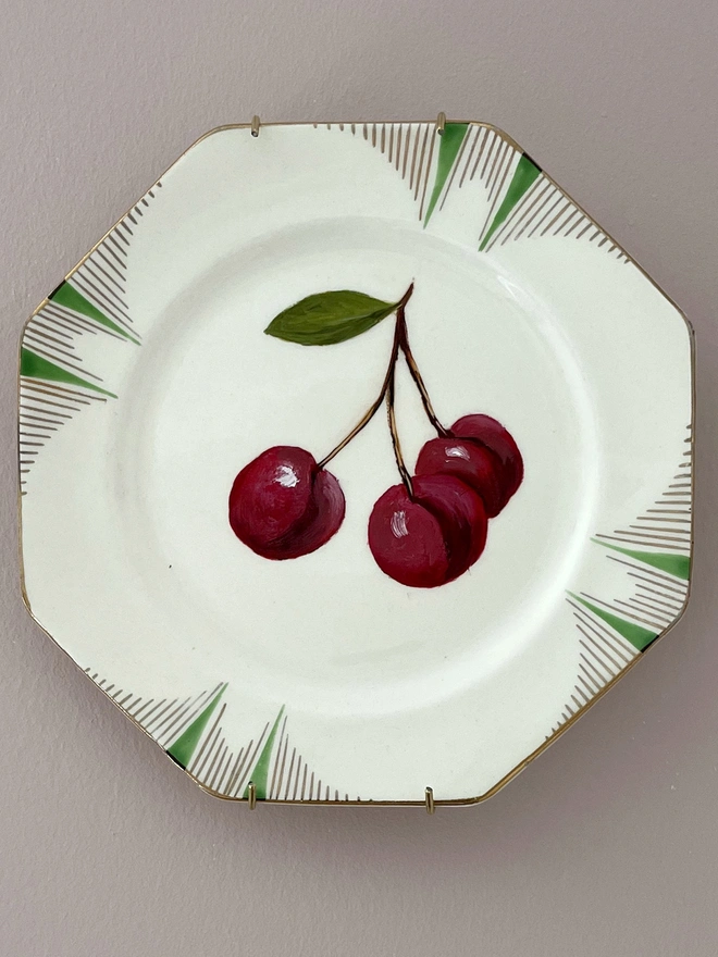 three cherries painted on art deco plate