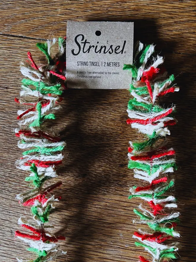 Close up of red, white and green Candy Cane jute string tinsel AKA Strinsel with label on an oak table