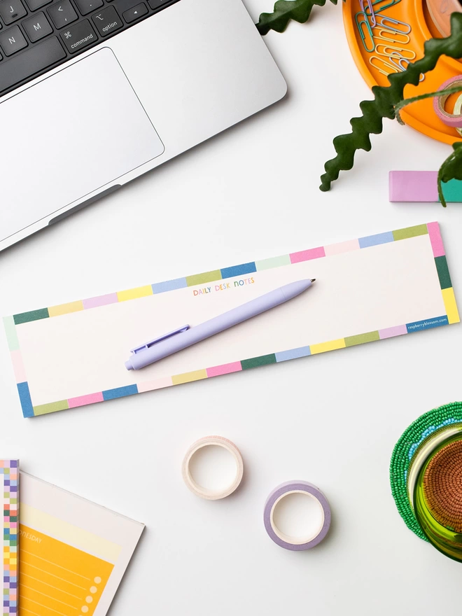 Keyboard notepad with ‘Daily desk notes’ in colourful hand lettering, with a rainbow tile design border 