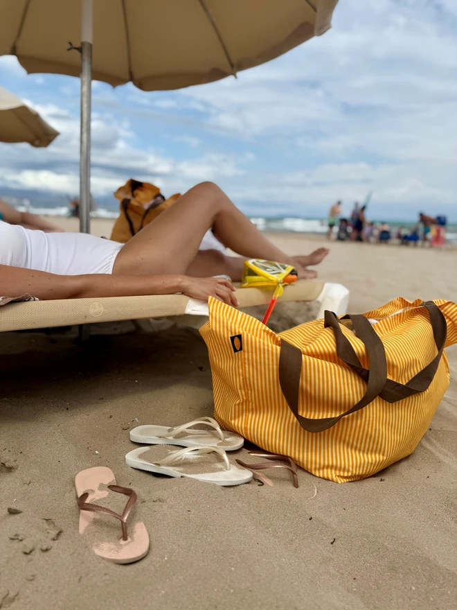 yellow stripe beach bag under cabana
