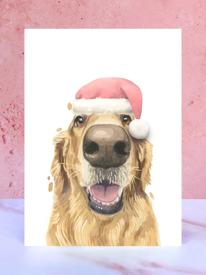 A Christmas card featuring a hand painted design of a golden retriever, stood upright on a marble surface. 