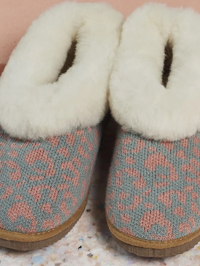 Women's Lambswool & Sheepskin Boot Slippers, a pair of boot slippers sitting on a decorated floor. 