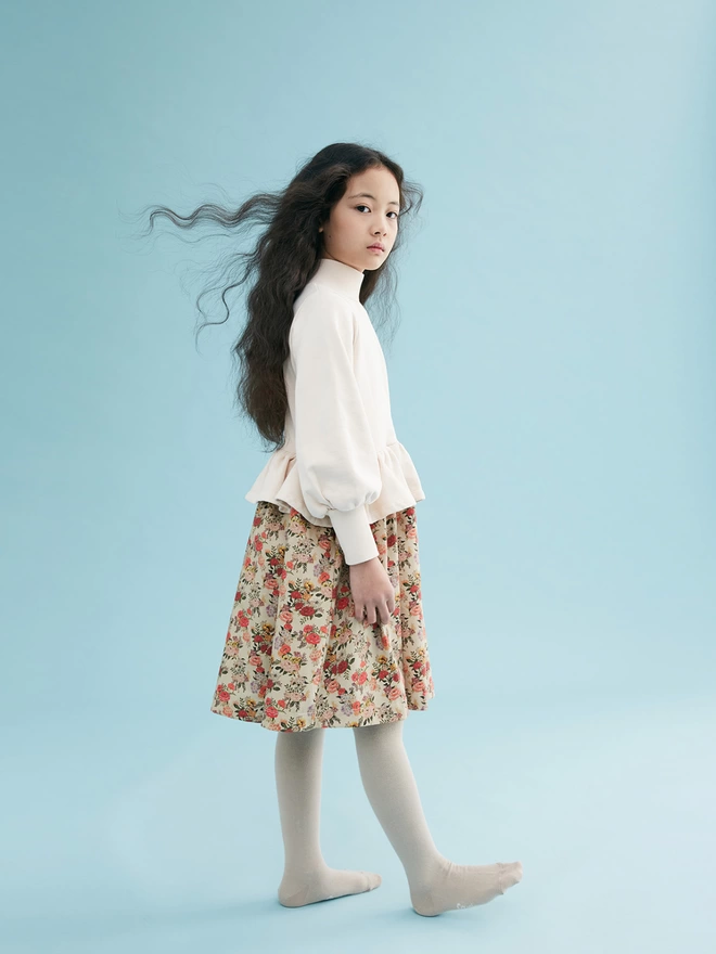 Cotton brushed back sweat to bodice and a cotton sateen dress in our own developed print to skirt. Featuring rib to the neck and deep cuffs, balloon sleeves and a fully gathered peplum.